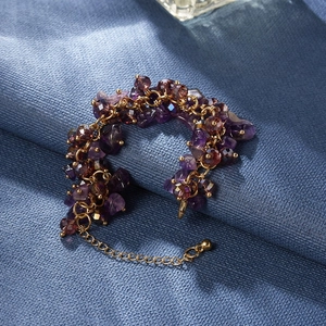 Detailed macro view of bohemian purple crystal beaded bracelet with gold chain extension