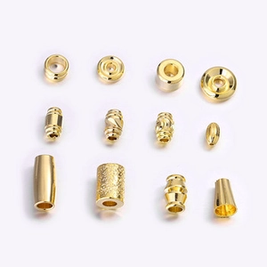 Detailed grid display of golden metal spacer beads and jewelry findings for DIY crafts
