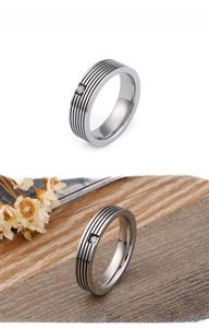 Detail view of titanium steel ring with black stripes and a single square zircon inlay