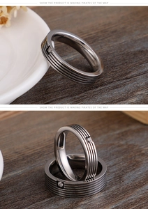 Macro detail of brushed stainless steel ring with center stone and parallel grooves