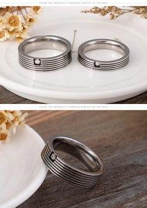 Macro detail of silver titanium steel rings featuring five stripes and center zircon stone