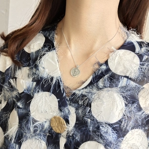 Close-up of vintage 925 sterling silver coin necklace featuring detailed rose flower relief