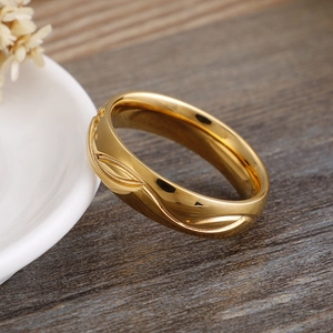 Bague polie en acier titane doré avec texture ondulée sur une assiette en céramique