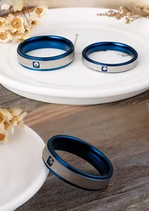 Detail of brushed titanium steel ring featuring blue plated edges and a single diamond