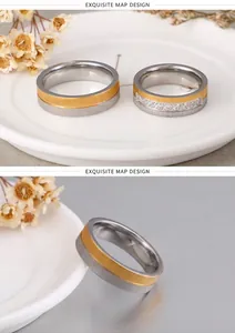 Detail of brushed titanium couple rings with two-tone gold plating and inlaid zircons
