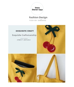 Detailed close-up of yellow canvas tote bag with cherry embroidery and outer pocket