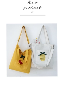 Detail view of canvas tote bags with 3D cherry and pineapple embroidery and front pockets