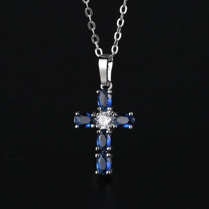 Elegant silver cross necklace with blue oval gemstones and a clear center zircon
