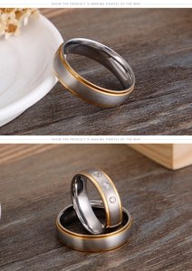 Detail of brushed silver and gold plated stainless steel wedding bands on wooden surface
