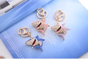 Three crystal shark keychains in pink, purple, and blue with gold lobster clasps