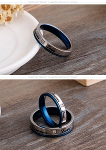 Detailed macro view of Forever Love engraved silver and blue couple rings with zircon stone