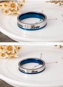 Detail of blue and silver steel couple ring with Forever Love engraving and zircon stone