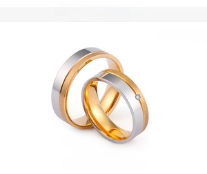 Détail de bagues de couple bicolores en acier titane plaqué or 18K avec une largeur de 6 mm