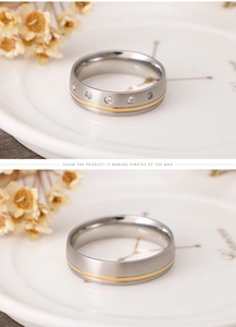 Macro detail of brushed stainless steel ring with gold groove and five inset zircons