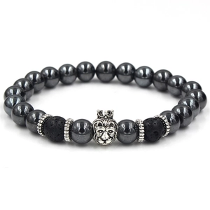 Macro detail of hematite beads and silver lion head crown charm on elastic bracelet