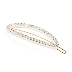 Detail shot of beige acetate hair clip with sparkling rhinestones and golden metal clip