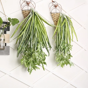 Detail showing artificial trailing plants with green leaves in a woven hanging basket