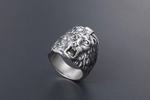 Close-up of vintage steel lion head ring showing intricate relief and metallic texture