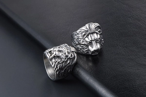 Detail of vintage lion head rings in antique silver finish on black leather background