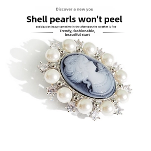 Close-up of vintage cameo brooch with white shell pearls and sparkling rhinestones