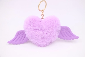 Close-up of purple faux fur heart keychain with wings and a golden metal ring