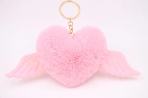 Close-up of pink heart plush keychain with soft wings and golden metal ring detail