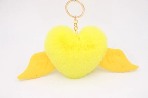 Detail of yellow plush heart keychain with wings and gold-tone metal ring