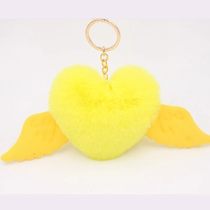 Close-up of yellow plush heart keychain with soft wings and a golden metal clasp