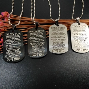 Detail of laser engraved black and silver military tag necklaces with inspirational quotes