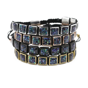Detail of four woven rope bracelets with square shell inlays in silver, gold, and black