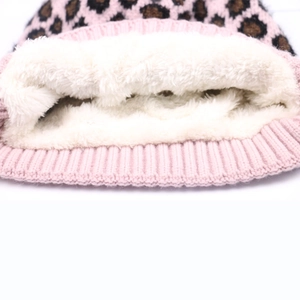 Detail of pink leopard print knit hat with soft white faux fur lining for winter warmth