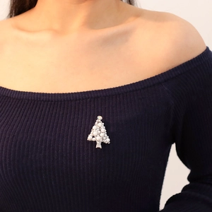 Elegant Christmas tree brooch with white pearls and rhinestones on blue fabric