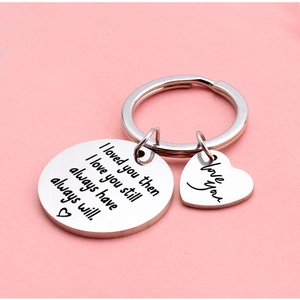 Silver stainless steel heart keychain with 'I love you' engraving on pink background