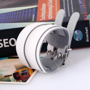 Close-up of white leather punk wristband with dual metal buckles and soft suede lining