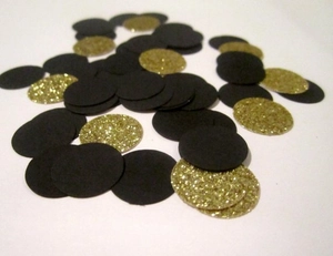 Detail of matte black and glitter gold round paper confetti scattered for party decoration