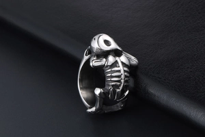 Macro side view of silver titanium steel skull ring with detailed skeleton carving