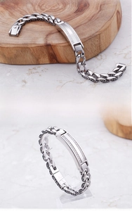 Close-up of a men's stainless steel curb bracelet with zircon inlays and vintage textures