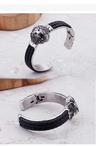 Makro-Detail von Herren-Edelstahl-Löwenkopf-Armband mit schwarzem Flechtband
