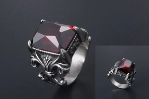 Detail of vintage steel ring with a large red square gemstone and brushed metal texture
