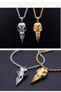 Macro detail of gothic stainless steel bird skull pendants in gold and silver finish