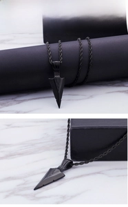 Détail macro du pendentif flèche noir mat pour homme avec motif géométrique en V
