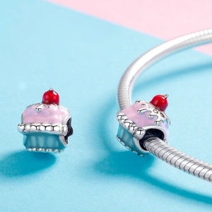 Macro shot of 925 sterling silver cupcake charm with pink enamel cream and cherry detail