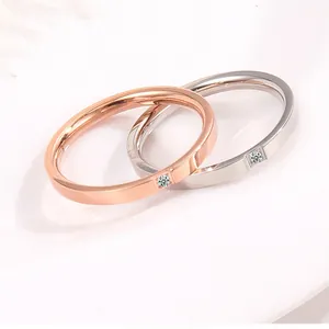 Close-up of rose gold and silver minimalist rings with a single sparkling zircon stone
