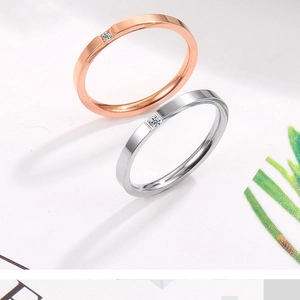 Macro detail of rose gold and silver minimalist rings featuring single square-cut diamonds