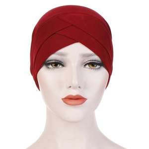 Deep red elastic turban hat with front cross design and pleated texture on white head model