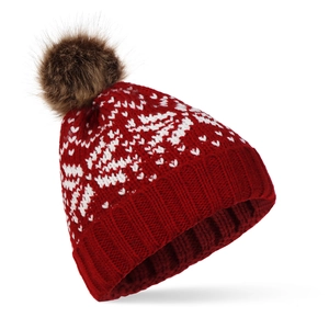 Détail du bonnet rouge tricoté avec motifs flocons de neige et pompon en fausse fourrure