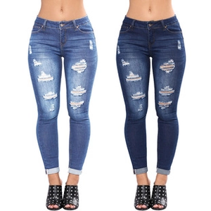 Detail view of high-waist distressed skinny denim jeans in light and dark blue wash