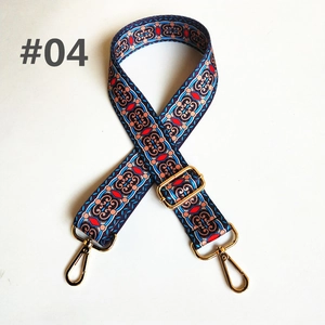 Close-up of ethnic geometric embroidery on wide adjustable handbag strap with gold buckle