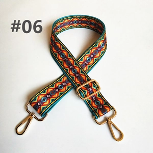 Detail of colorful geometric ethnic bag strap with golden metal hooks and adjustable buckle