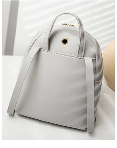 Detail view of the light gray PU leather backpack showing the headphone jack and straps
